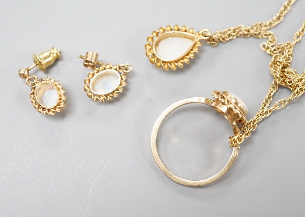 A modern suite of 9ct gold and white opal jewellery, comprising a ring, pendant on chain and pair of earrings, gross weight 9.1 grams.